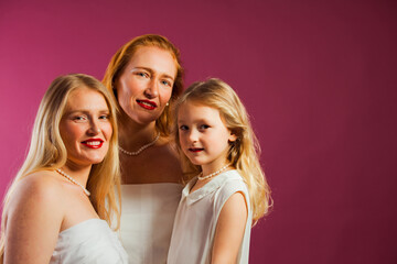 Obraz premium Happy women and schoolgirl posing, smiling and hugging