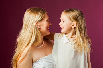 Portrait of mother and daughter isolated on purple background
