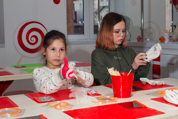 Two girls take part in a master class on making caramel.