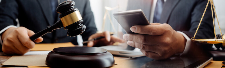Business and lawyers discussing contract papers with brass scale on desk in office. Law, legal services, advice, justice and law concept picture with film grain effect