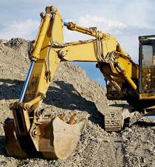 Excavator at work: the mechanical shovel of a bulldozer in an excavation site.