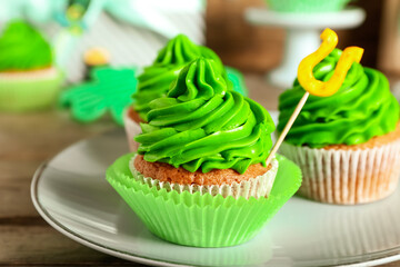 Plate tasty cupcakes for St. Patrick's Day on table, closeup