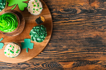 Fototapeta na wymiar Tasty cupcakes for St. Patrick's Day on wooden background