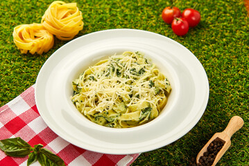 Traditional italian Pasta tagliatelli with spinach, hard parmesan cheese and cream sauce