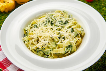 Traditional italian Pasta tagliatelli with spinach, hard parmesan cheese and cream sauce