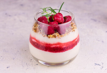 
Raspberry dessert with cream cheese and granola on a white plate.