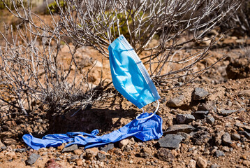 A medical mask and a pair of protective gloves to protect against the coronavirus carelessly thrown...