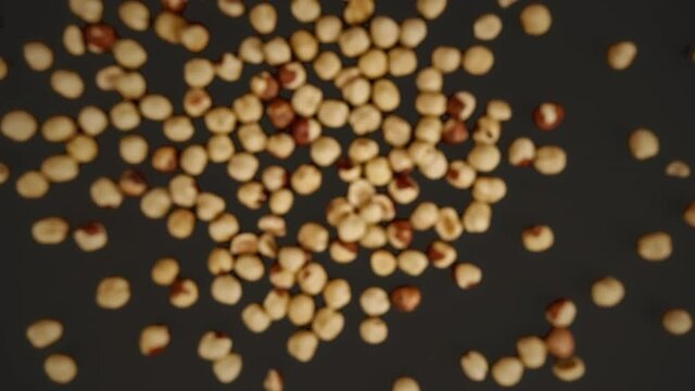 Slow motion of flying peeled hazelnuts a black background