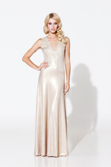 Fashion concept. Beautiful young blond lady in light golden evening dress isolated on white...