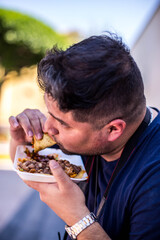 Mexicano comiendo tacos de guisos sentado en mexico