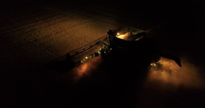 Tractor harvesters working at night countryside corn fields drone aerial view 4K 