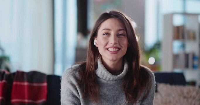 Portrait of pretty millennial young woman with earphones videochatting on camera speaking online lecture educational lesson speech with online students.