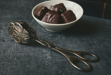 Old silver tongs for cake and dessert, shallow depth of field, vintage, stylized