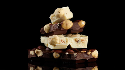 chocolate dark and white. stack of chocolate bar on black background. chocolate with nuts. confectionery concept