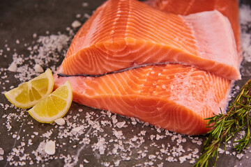 Fresh raw fillet of sea fish salmon or trout with spices and herbs on a dark background. The concept of cooking fresh fish in a restaurant or at home in the kitchen