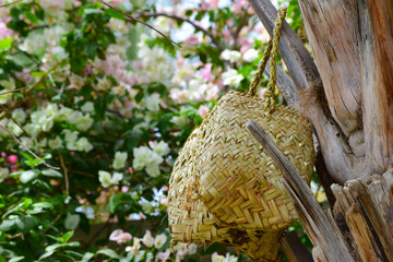 Human hand made dates tree box tool. palm leaf dry jar hanging on wood in garden, brown background culture thing Arabic style picture