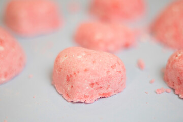 selective focus of a bath bomb from sea salt, citric acid, soda, dye and flavor on a blue background