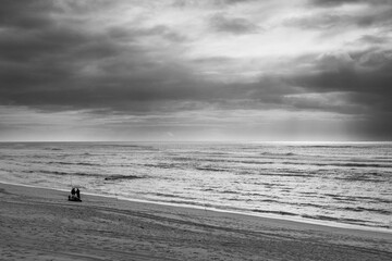 Fototapeta na wymiar people admiring the vastness of the sea from a beach