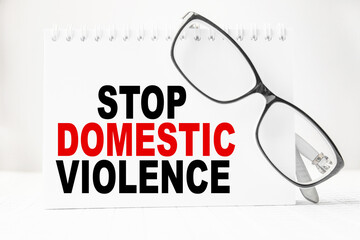 Notepad with inscriptions STOP DOMESTIC VIOLENCE on a white background. business concept.
