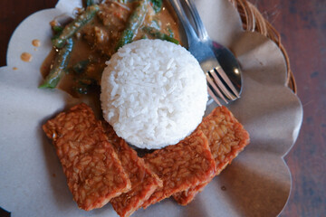 Close up of pecel rice on a wooden table. Pecel rice is a traditional food from Java, Indonesia 