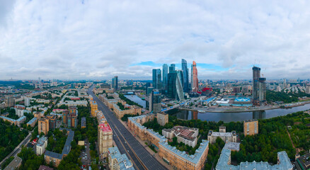 Large panorama view of summer Moscow with skyscrapers of Moscow-City - a business district on the embankment of Moskva River on a cloudy day, Russia. Top view aerial cityscape from the drone.