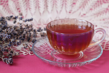 Tea cup on the background of an openwork white napkin with a bouquet of lavender, close-up