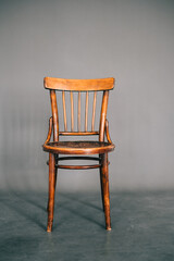 Vintage wooden chair on gray background.