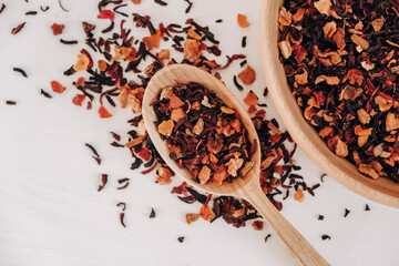 Dry fruit tea in a wooden spoon scattered on a white background. Top view. Copy, empty space for text