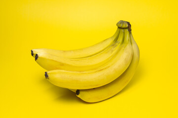 Bananas on a yellow background. Fresh yellow bananas. Banana bunch. Exotic fruit