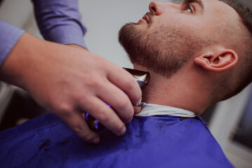 Fototapeta premium Young Man in Barbershop Hair Care Service Concept
