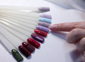 The process of manicure fitting natural nails filing nails coating with colored gel polish and glossy top.
