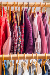 Fototapeta premium Clothes are hanging on hangers. Lots of clothes for sorting things in the wardrobe.