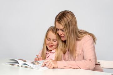 Mom helps little daughter to do homework