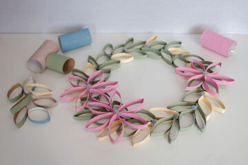 Wreath from toilet roll tube for Easter celebration, zero waste craft for kids, school and kindergarten, creative seasonal idea for spring holidays and leisure, plain neutral pastel background