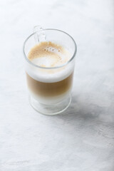 Coffee with milk on bright wooden background. Close up. Copy space.