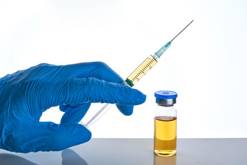 Male doctor hand in blue glove holds syringe and vial bottle with drug multiple injections dose.