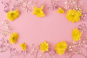Easter concept. Eggs and yellow chrysanthemums flowers on pink background. Mock up. Spring Happy Easter holiday card. Top view.