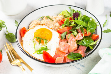 Savory breakfast. Oatmeal porrige with salted salmon, egg and fresh salad. Healthy food, balanced nutrition.
