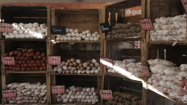 A store full of various kinds of sausages on shelves. A shop offering clients a wide variety of sausages to buy. specific sausages shop in France