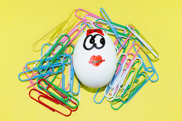 Egg with a smile and colored paper clips.