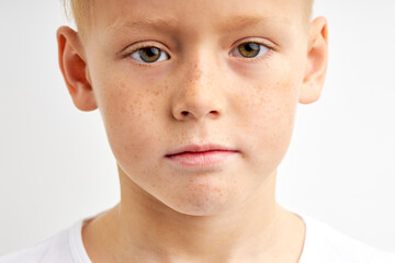 close-up portrait of teenager boy with shy diligent look, having green big eyes, seriously looking...
