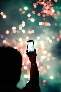 Person taking photos of fireworks using smartphone