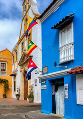 houses in the walled city of cartagena with cuban flag, cartagena de indias flag, and colombian flag