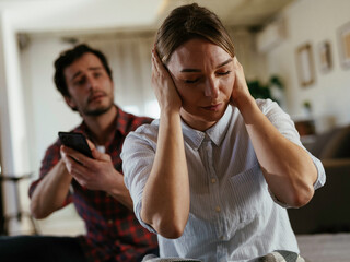 Husband and wife are arguing at home. Angry man is yelling at his wife.