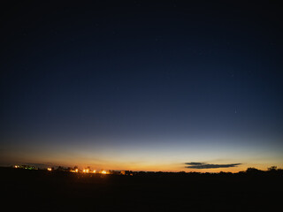 dark night sky, distant lights on the horizon, the sun had just set