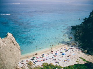 Italy, Sardinia, view of a beautiful beach with tourists and azure water