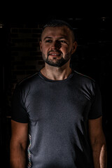 Fototapeta premium Smiley guy in black t-shirt, portrait. Portrait of handsome single bearded young man with serious expression wearing.