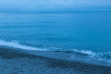 beautiful, blue sea with waves, beach, rocks in the evening on a nice, warm evening in travel