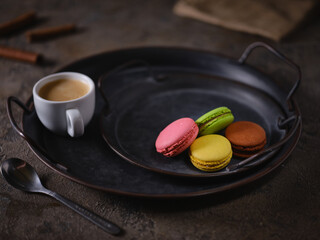 Obraz na płótnie Canvas Macaroon cookies on a vintage tray and a cup of espresso