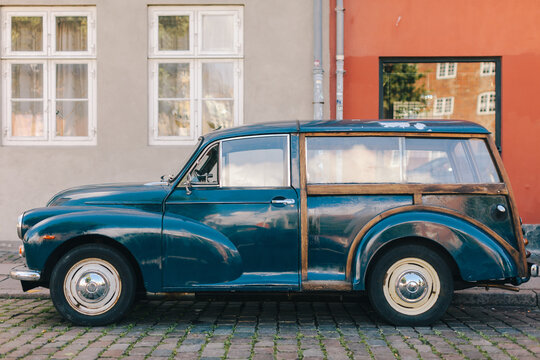 Old car parked in front of house wall
